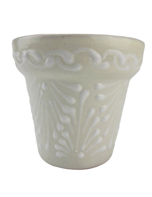 White ceramic planter with decorative patterns on a white background