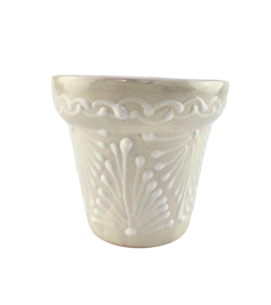 Decorative white ceramic planter with intricate patterns on a white background