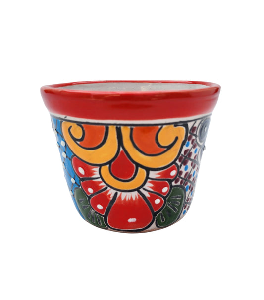 Colorful small ceramic planter with floral design on a white background