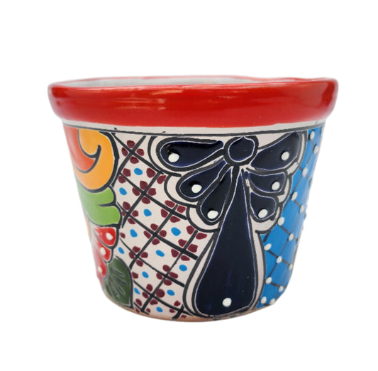 Colorful ceramic planter with decorative patterns on a white background