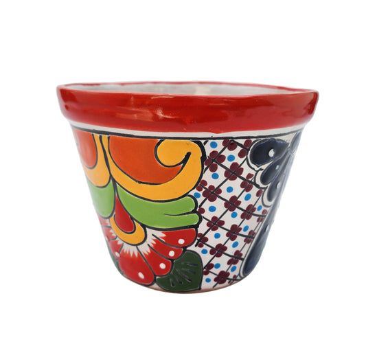 Colorful ceramic planter with floral patterns on a white background