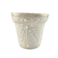 Decorative white ceramic planter with intricate patterns on a white background