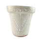 Decorative white ceramic item with intricate patterns on a light gray background