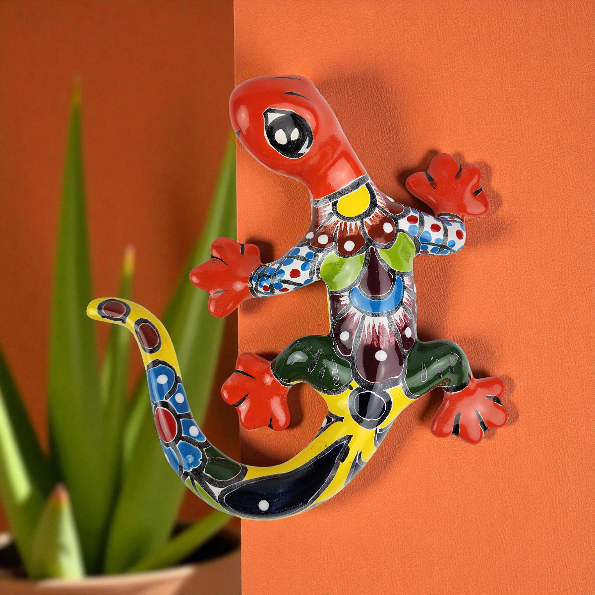 Colorful ceramic lizard wall art on an orange background