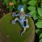 Colorful ceramic salamander on a green surface with leaves in the background
