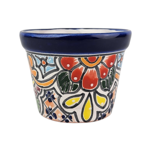 A small hand-painted ceramic pot with a dark blue glazed rim and a colorful Mexican Talavera-style floral pattern on a white background.