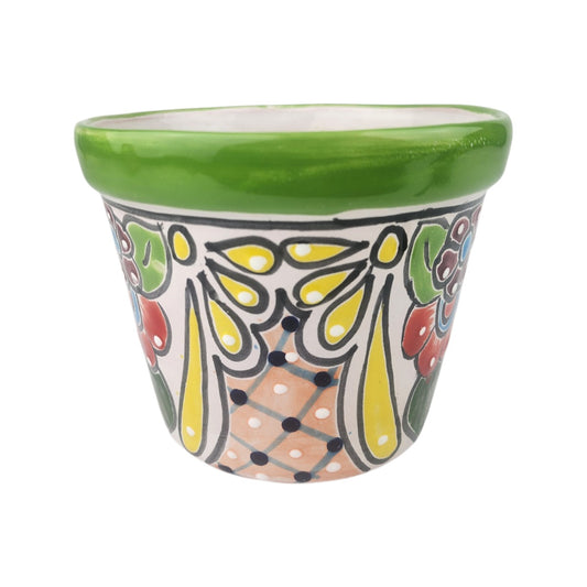 A small hand-painted ceramic planter pot with a glossy green rim and a colorful folk-art style pattern on a white background.