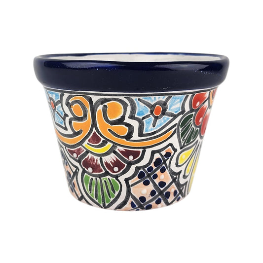 A small hand-painted ceramic planter pot with a dark blue glazed rim and a colorful, hand-drawn traditional pattern on the body, set against a plain white background.