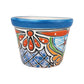 A small hand-painted ceramic planter pot with a vibrant blue rim and a colorful traditional pattern featuring orange, blue, green, and black on a white background.