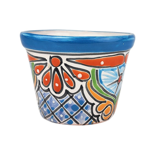 A small hand-painted ceramic planter pot with a vibrant blue rim and a colorful traditional pattern featuring orange, blue, green, and black on a white background.