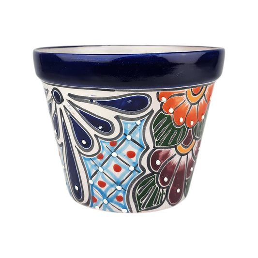 A small hand-painted ceramic planter pot with a dark blue glazed rim and a colorful floral and geometric pattern on a white background.