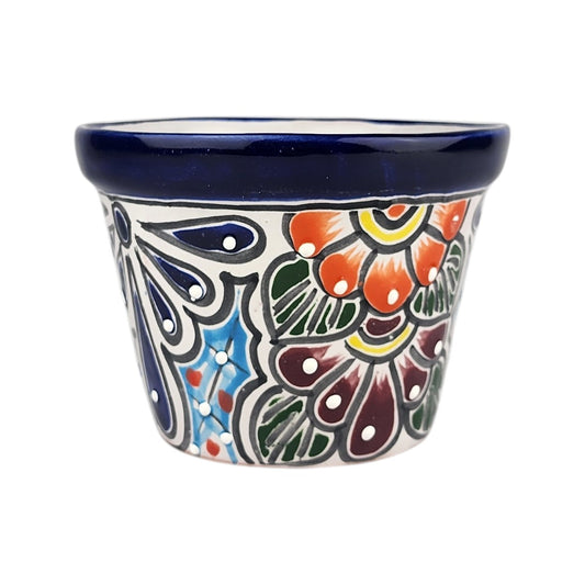A small hand-painted ceramic pot with a dark blue glazed rim and a colorful floral pattern on a white background.
