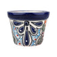 A hand-painted ceramic planter pot with a deep cobalt blue glazed rim and a white body decorated with blue, black, light blue, green, and red hand-painted patterns.
