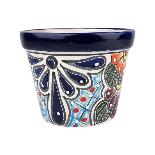 A hand-painted ceramic planter pot with a dark blue glazed rim and a colorful hand-painted floral and geometric pattern on a white background.