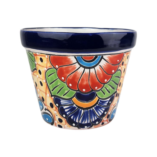 A hand-painted ceramic planter pot with a dark blue glazed rim and a colorful floral pattern on a cream background.