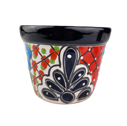 Ceramic planter with colorful floral design on a white background