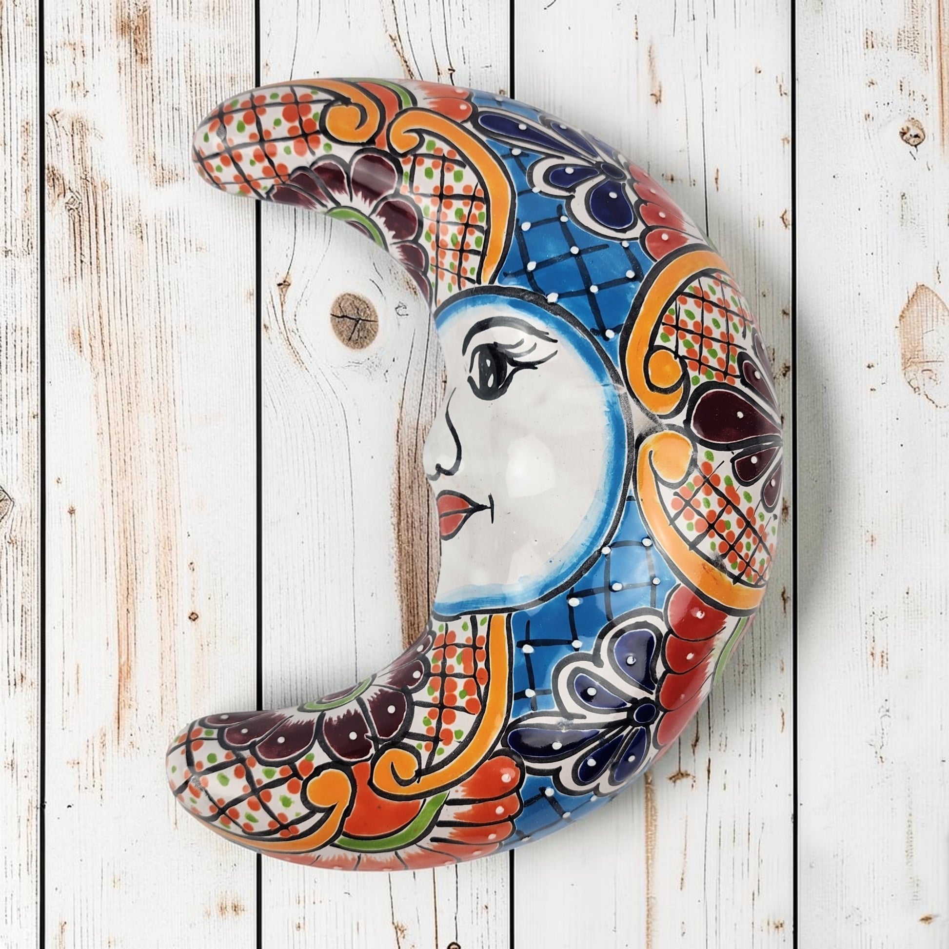Blue Talavera-style ceramic moon wall décor with colorful floral and geometric patterns on white background