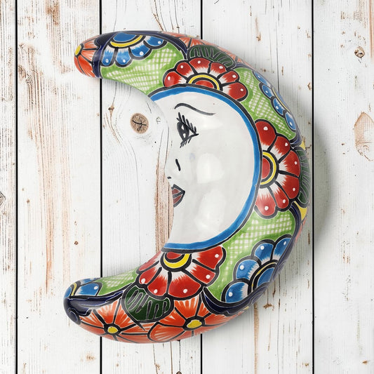 Talavera-style ceramic moon wall décor with colorful floral patterns on rustic white wood background