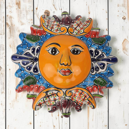 Blue Talavera-style ceramic sun wall décor with colorful floral and geometric patterns on rustic white wood background