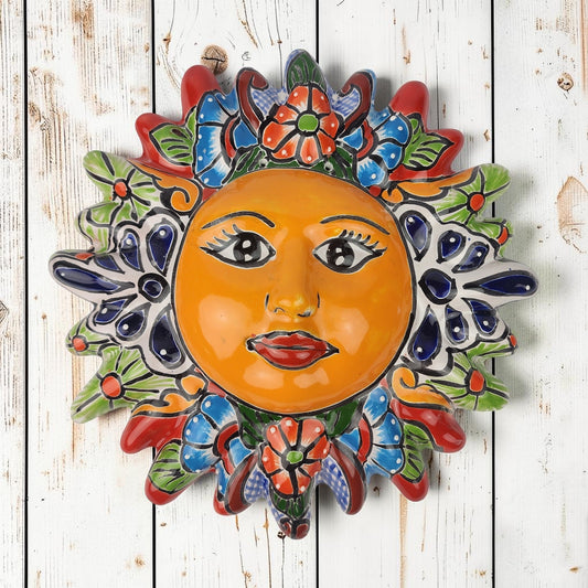 Red Talavera-style ceramic sun wall décor with colorful floral patterns displayed on rustic white wood background