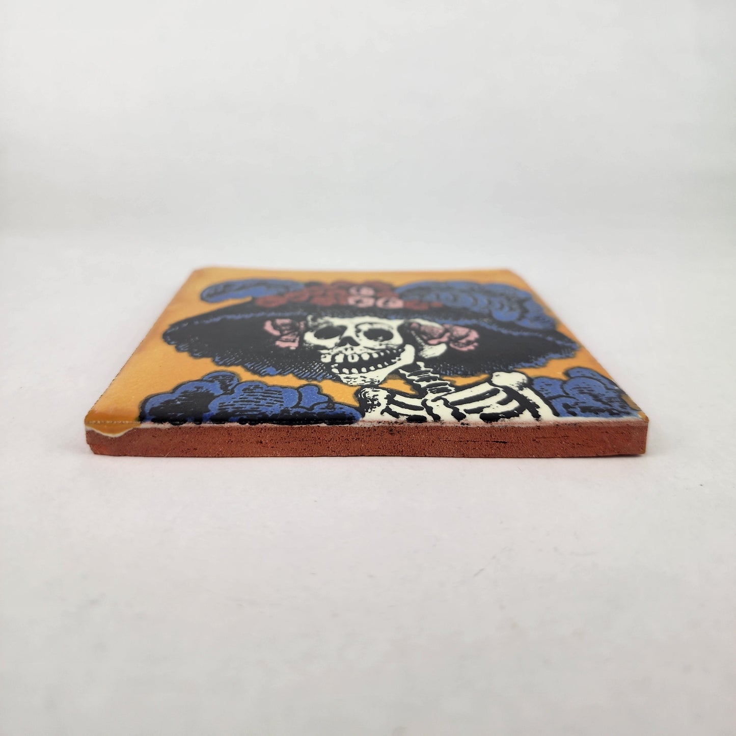 Golden yellow Catrina Portrait ceramic tile shown from front edge highlighting ceramic thickness and natural terracotta edge