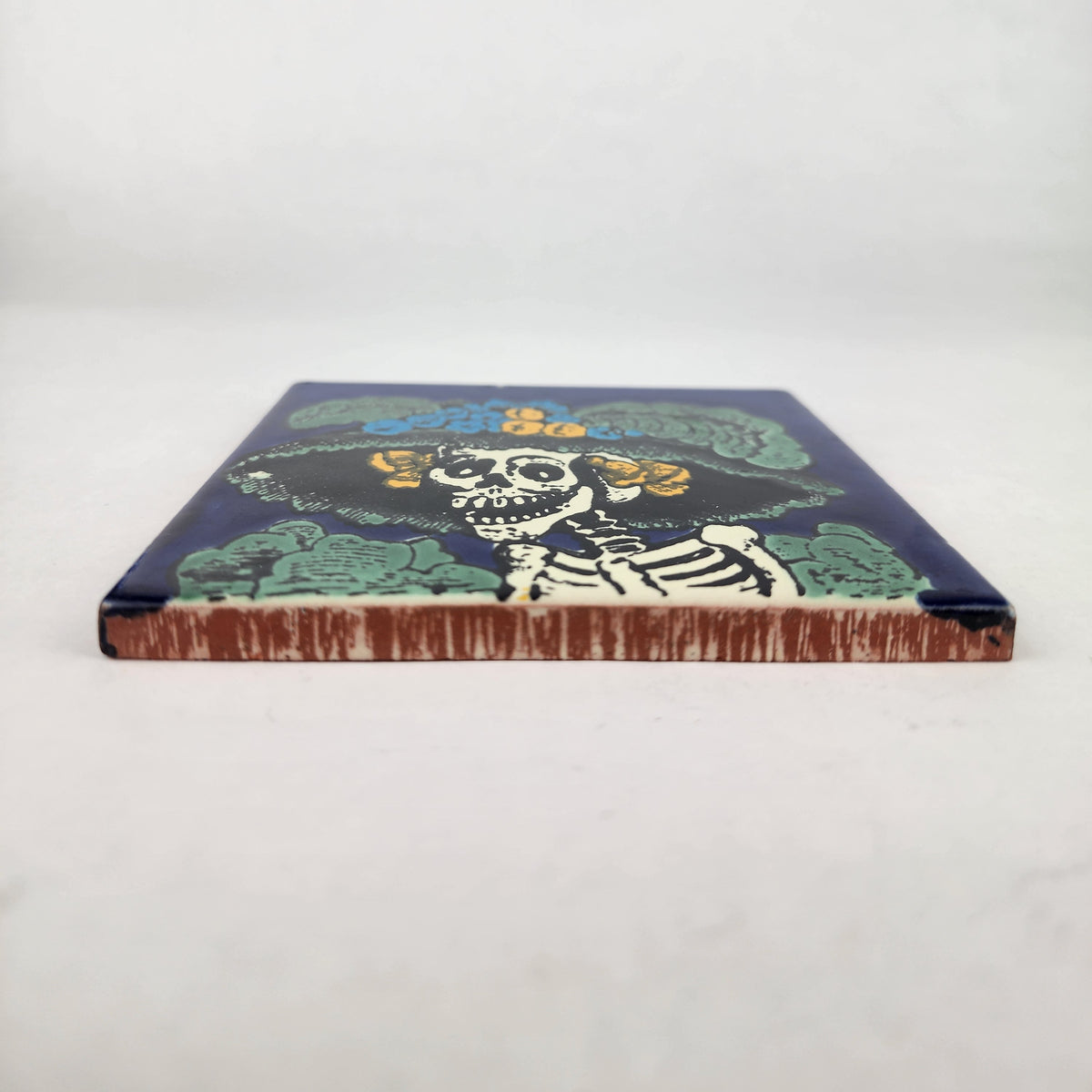 Blue Catrina Portrait ceramic tile shown from front edge highlighting ceramic thickness and glazed surface