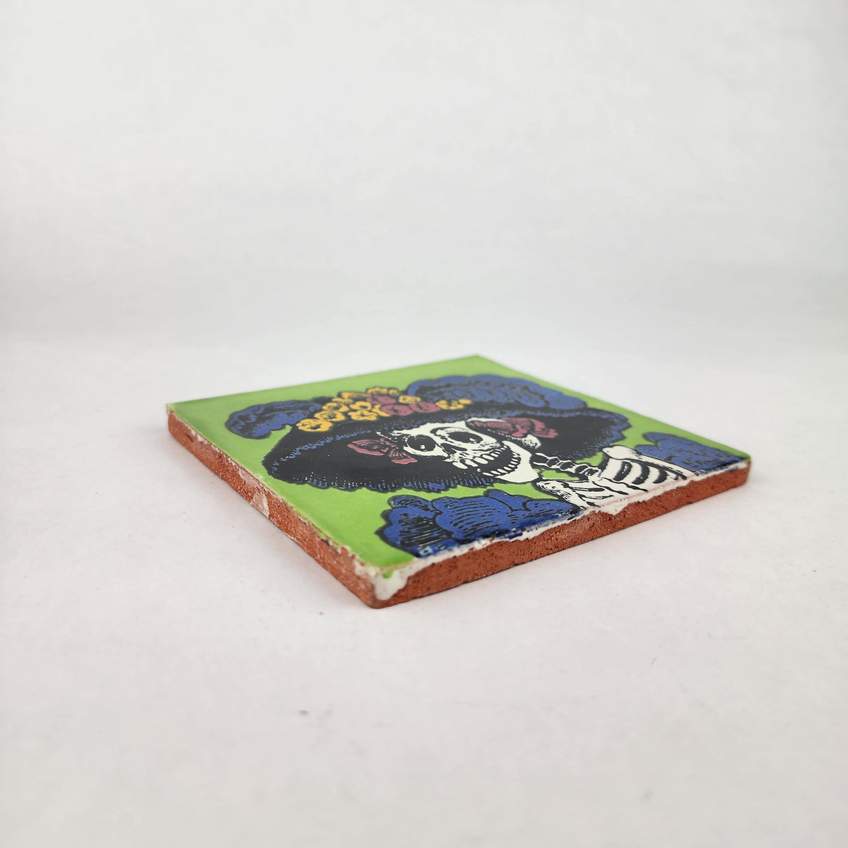 Angled view of lime green Catrina Portrait ceramic tile showing glossy surface and natural terracotta edges