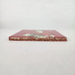 Brick red Frida Kahlo ceramic tile shown from front edge highlighting ceramic thickness and terracotta edge