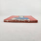 Side view of red orange Frida Kahlo portrait ceramic tile showing thickness and ceramic edge