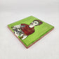 Angled view of lime green Frida Kahlo portrait ceramic tile showing glossy surface and natural terracotta edges