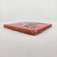 Angled view of Skeleton Motorcycle ceramic tile with red background showing glazed surface and ceramic edge