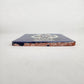 Side view of 4 1/8 inch floral sugar skull ceramic tile showing thickness and glazed edge