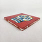 Angled view of red Mexican ceramic tile with colorful floral sugar skull design
