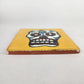 Side view of 4 1/8 inch floral sugar skull ceramic tile showing thickness and glazed edge
