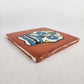 Angled view of copper brown Mexican ceramic tile with colorful floral sugar skull design