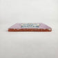 Side view of 4 1/8 inch floral sugar skull ceramic tile showing thickness and glazed edge