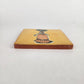 Side view of mustard yellow Catrina ceramic tile showing glazed surface and terracotta edge