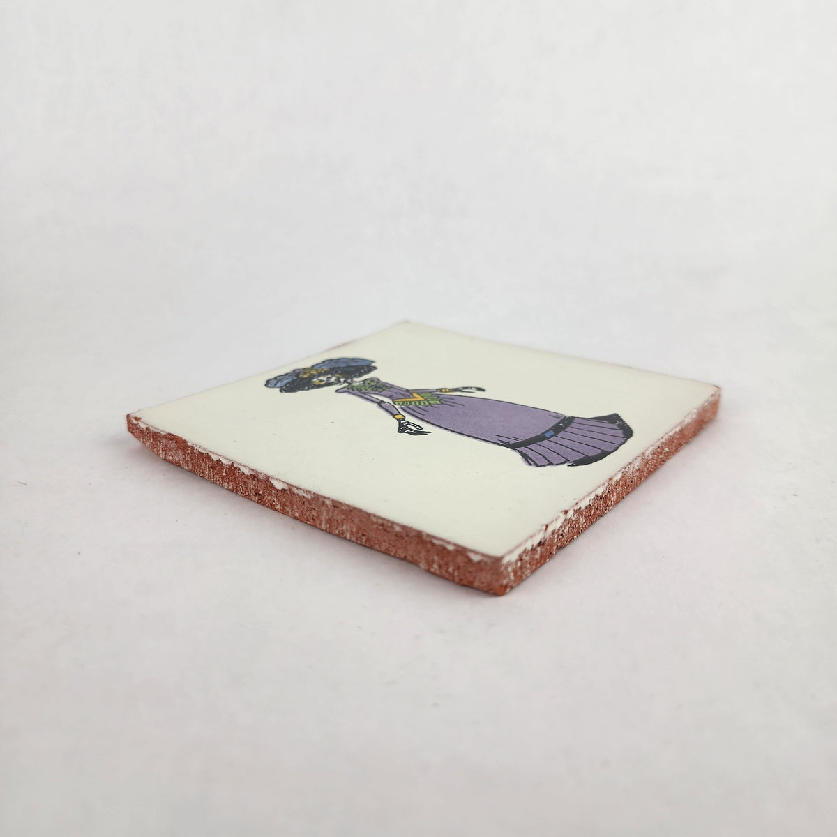 Angled view of white Catrina ceramic tile with purple dress and natural terracotta edges