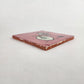 Angled view of pink skeleton bicycle ceramic tile showing glazed surface and ceramic edge