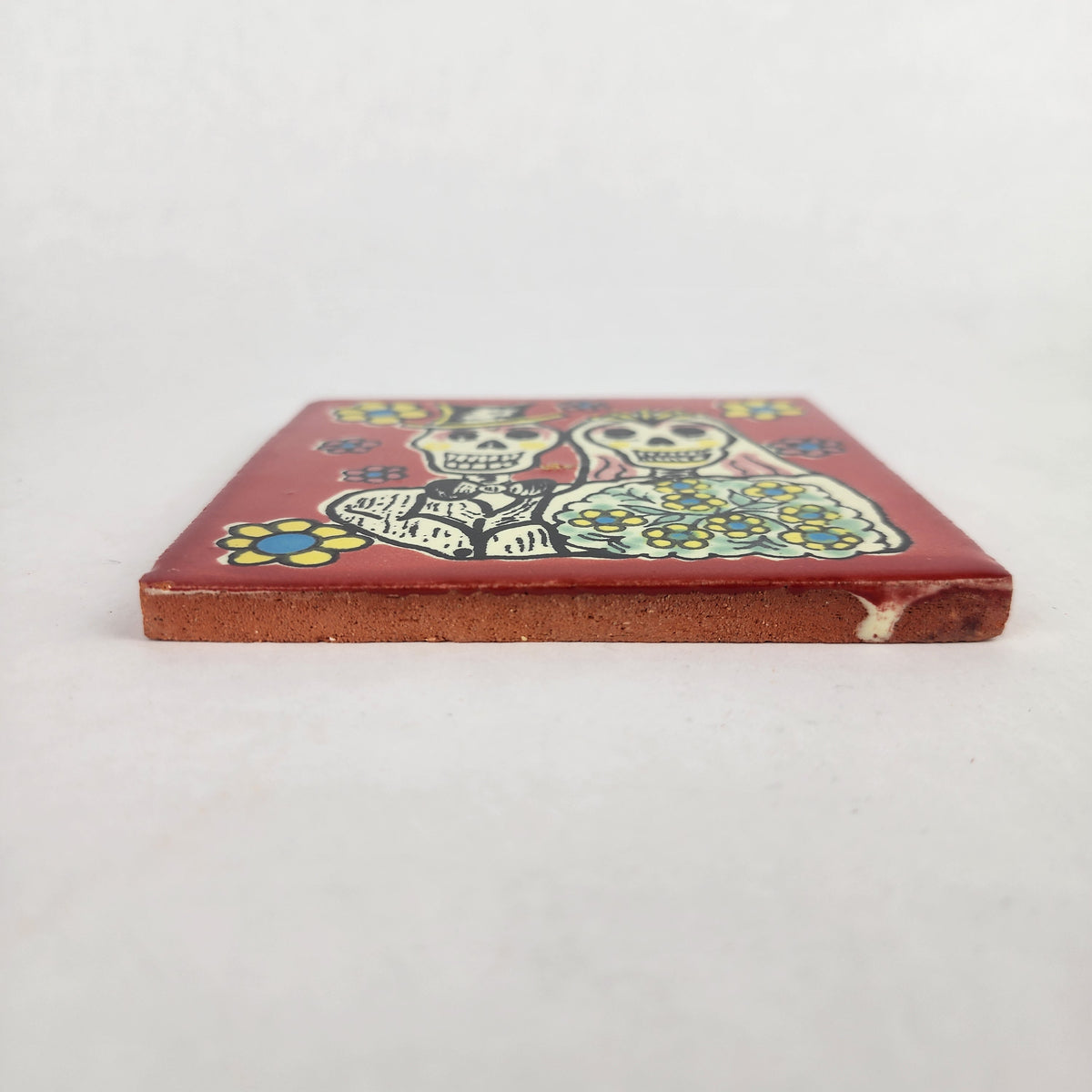 Side view of red skeleton wedding ceramic tile showing thickness and ceramic edge