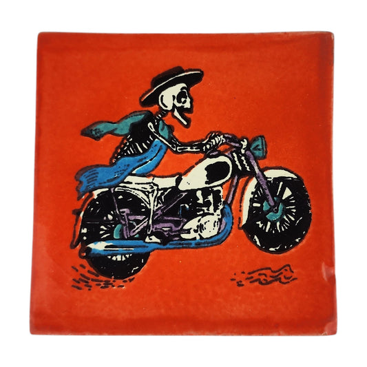 Skeleton Motorcycle ceramic tile with red-orange background and Mexican folk art design