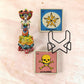 Mexican folk art Catrina and Lotería coaster gift set with ceramic Catrina figurine, La Calavera #42 coaster, La Estrella #35 coaster, and black metal holder.