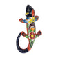 Deep blue Talavera-style ceramic iguana with colorful floral and geometric patterns displayed on a white 
