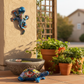 Handcrafted sky blue ceramic turtle and salamander folk art displayed on a patio with planters, Talavera-style Mexican decor