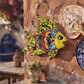 Yellow Talavera-style ceramic fish wall décor displayed on a stucco wall in a Mexican-inspired outdoor space.