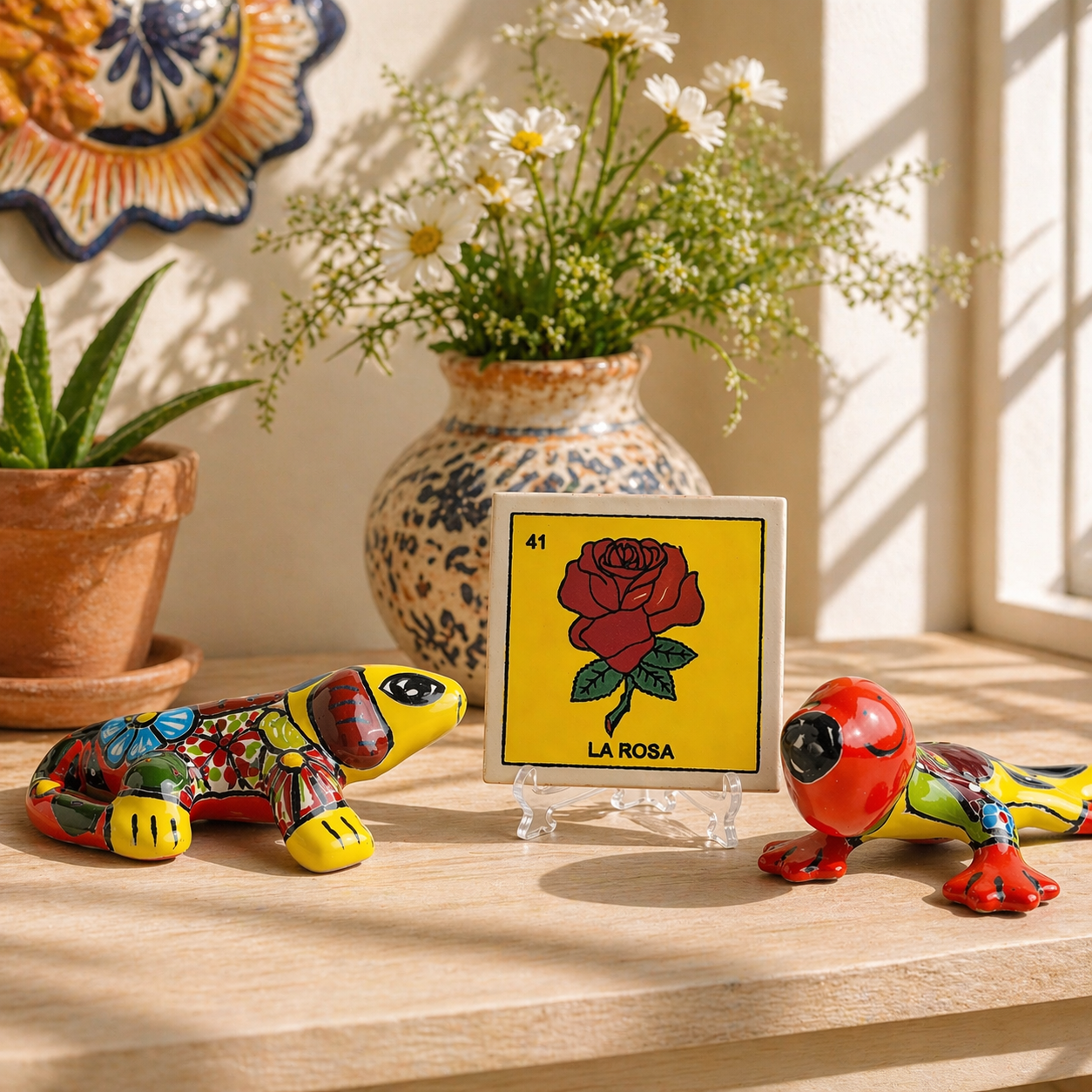 Decorative items including a colorful iguana, red gecko, and a loteria tile titled 'La Rosa' on a wooden surface.