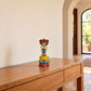 Multicolor hand-painted ceramic Catrina figurine displayed on a wooden entryway console.