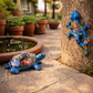 Sky blue Talavera-style ceramic turtle and salamander displayed together outdoors near a pond, handcrafted Mexican folk art patio decor set