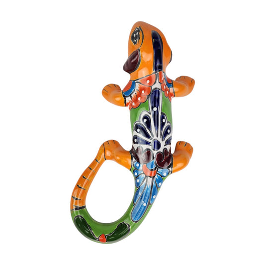 Orange Talavera-style ceramic iguana with colorful floral and geometric patterns displayed on a white background.