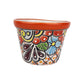 Red orange rim ceramic planter with blue and orange flowers, burgundy teardrop motifs, green leaves, and a dotted lattice pattern on a white background.